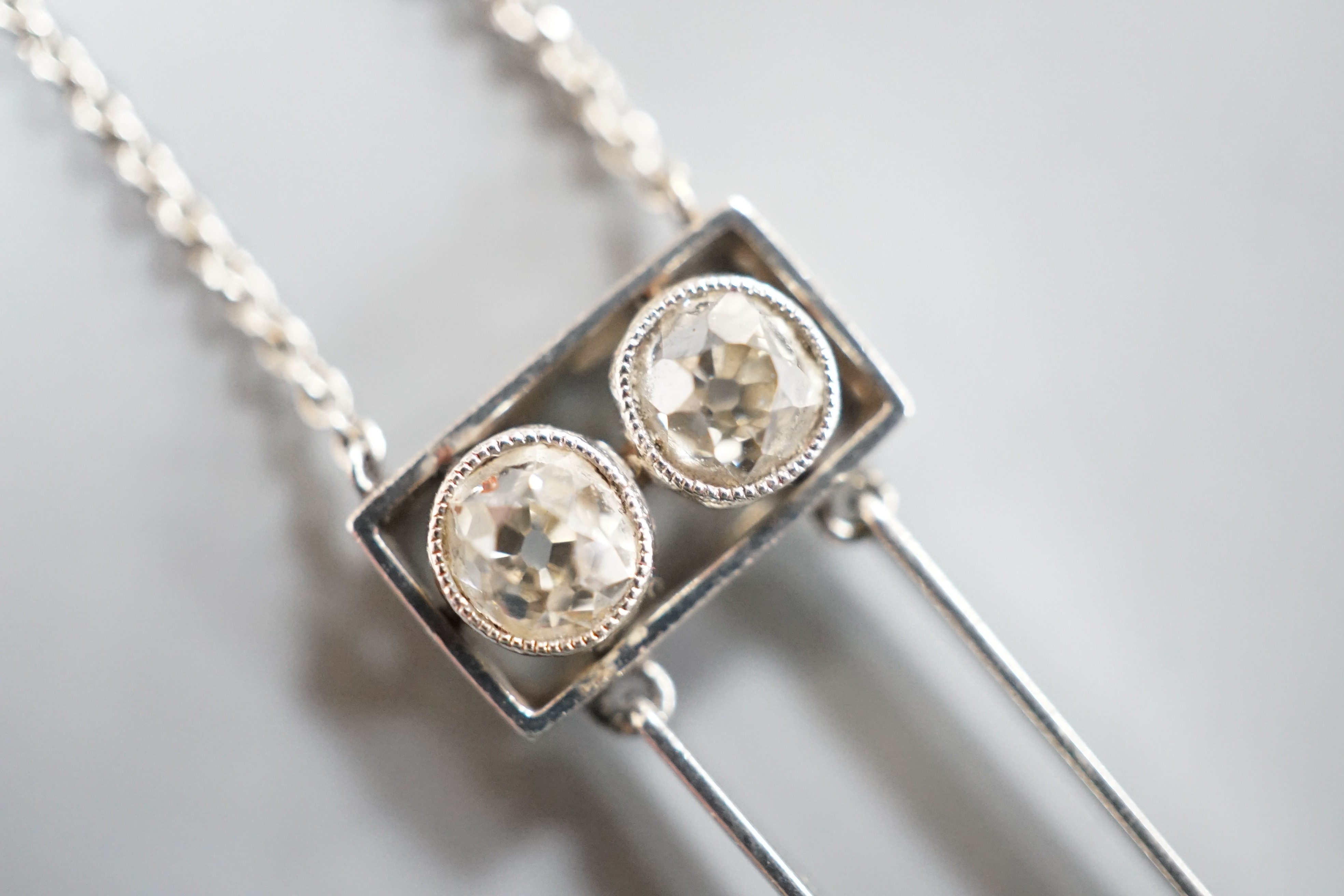 A 1940's white metal (probably platinum), three stone diamond and single stone teardrop shaped pearl set double drop pendant necklace, pendant 39mm, chain 41cm, gross weight 5.9 grams.